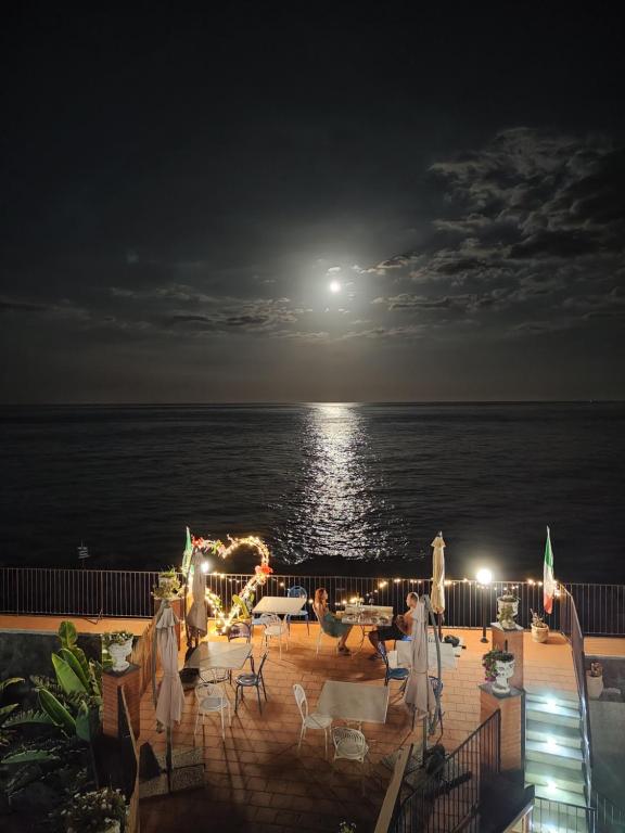 einen Blick auf das Meer bei Nacht mit dem Mond in der Unterkunft Made in Sicily Santa Tecla in Acireale