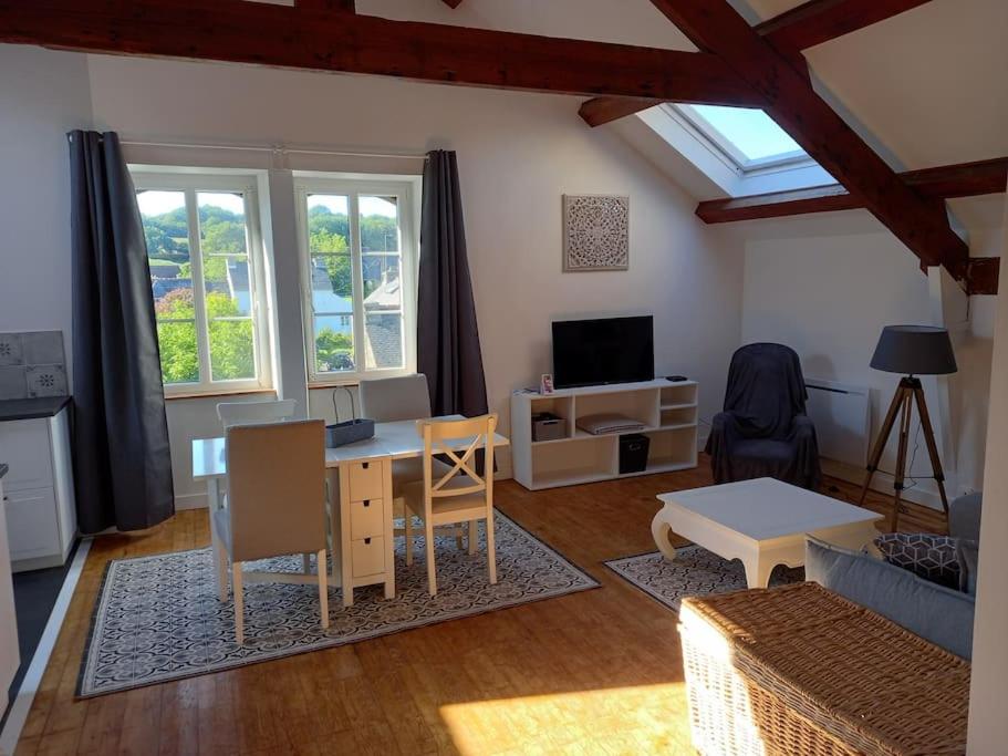 un salon avec un canapé, une table et une télévision dans l'établissement Au coeur de Sainte-Christine, à Kervizic