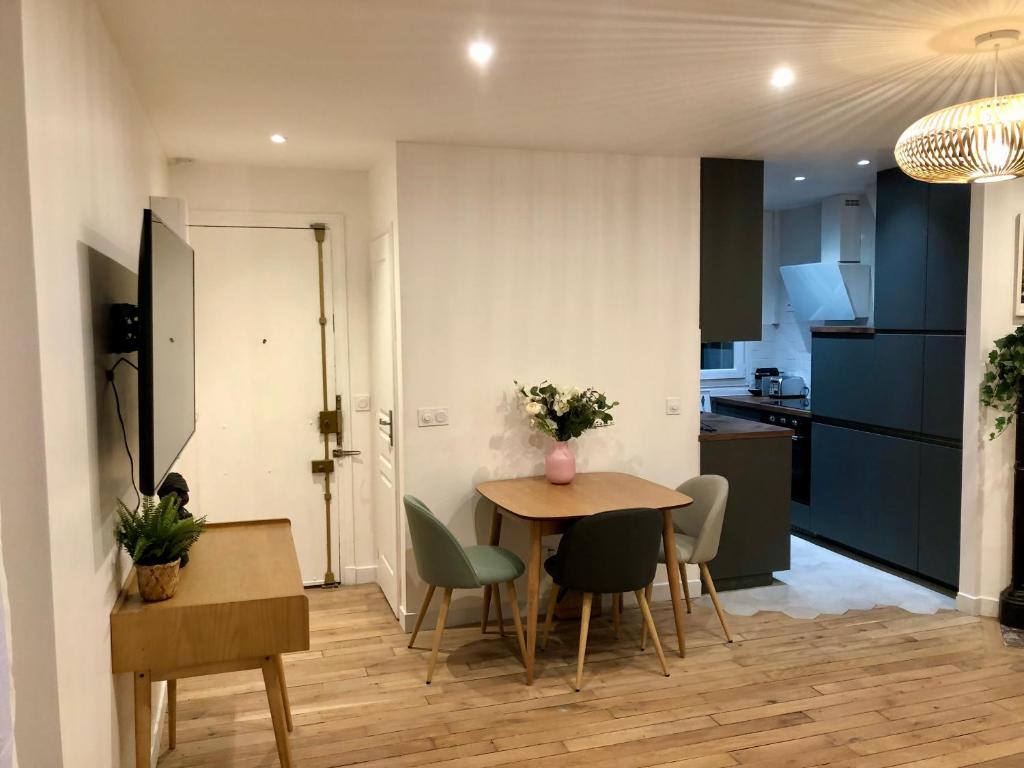 una cucina e una sala da pranzo con tavolo e sedie di Rare appartement d'architecte en haut de Montmartre a Parigi