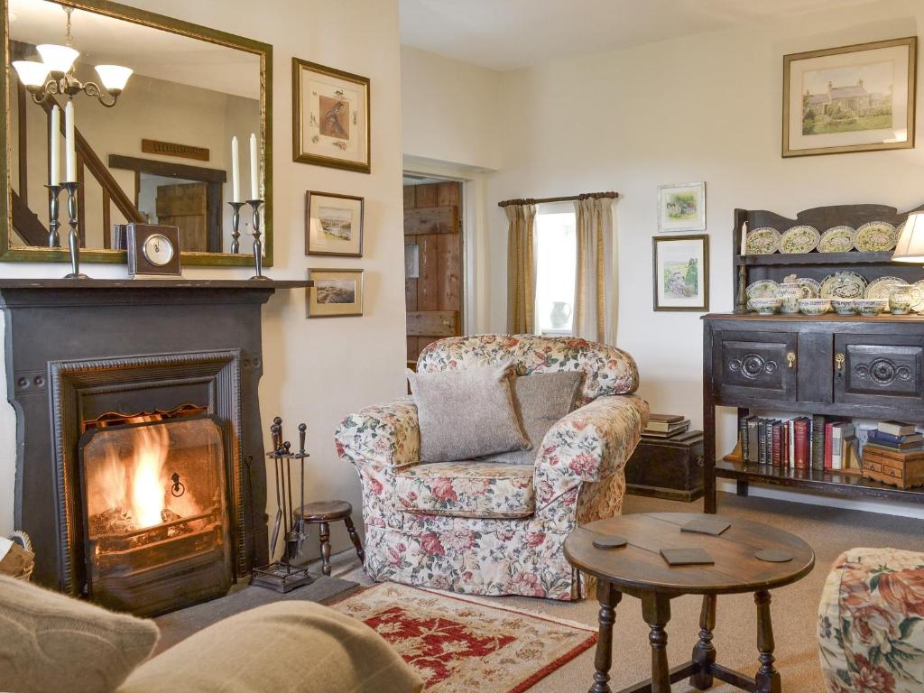 a living room with a fireplace and a chair at Bryn Tirion in Llantrisant