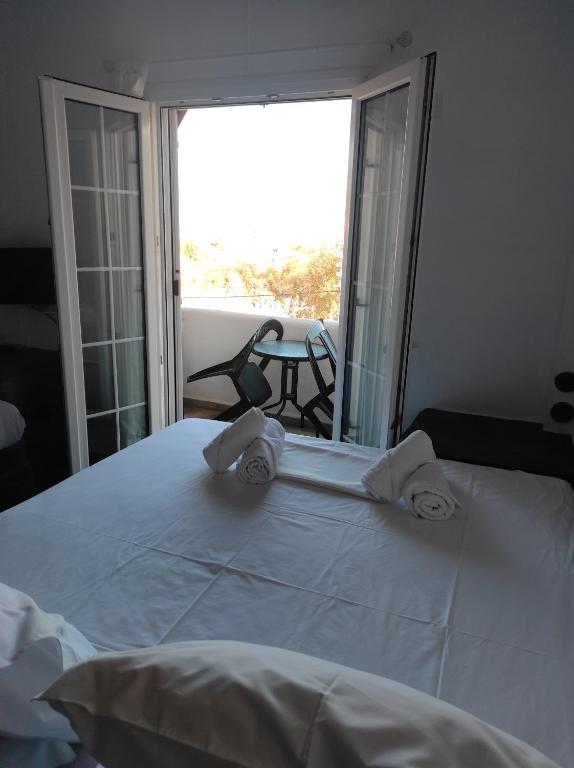 una camera da letto con un grande letto bianco con asciugamani di Kea Island II a Korissía