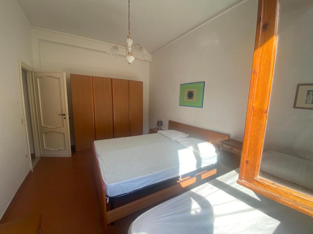 ein kleines Schlafzimmer mit einem Bett und einem Spiegel in der Unterkunft Casa sud fronte mare in Follonica