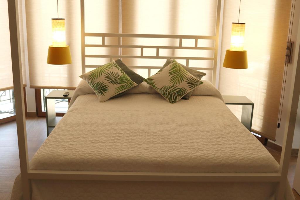 ein Schlafzimmer mit einem Bett mit zwei Lampen in der Unterkunft APARTAMENTOS GORI SUITES HIDROMASAJE accesibles minusválidos in Villafranca del Cid