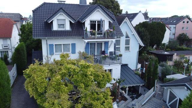 a white house with a balcony on top of it at Ferienwohnung Brossmann in Eltville