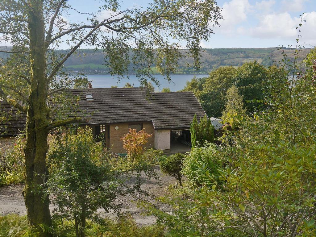 una pequeña casa con un lago en el fondo en Rosmuire, en Rhu