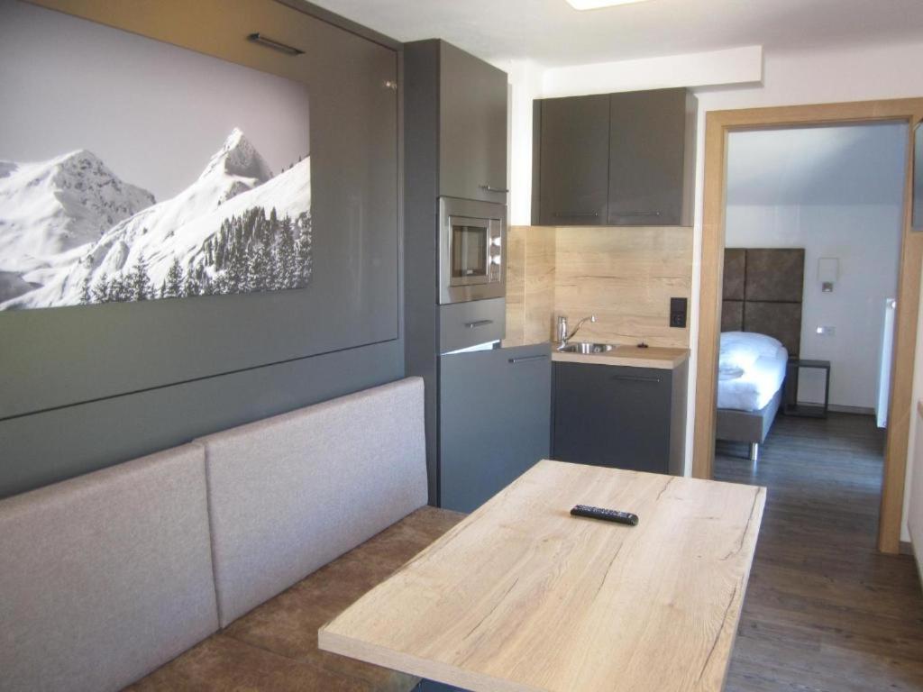 eine Küche mit einem Tisch mit einem Bild an der Wand in der Unterkunft Haus Kohlbründl in Saalbach-Hinterglemm