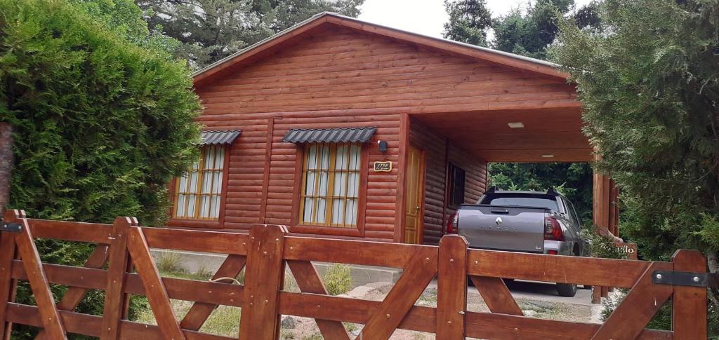 a wooden cabin with a car parked in front of it at Cabaña potrerillos La Tabaida in Potrerillos