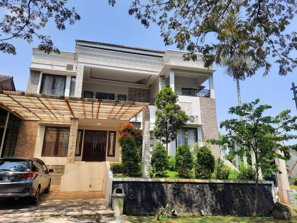 a house with a car parked in front of it at Villa Bukit Nirwana in Bogor