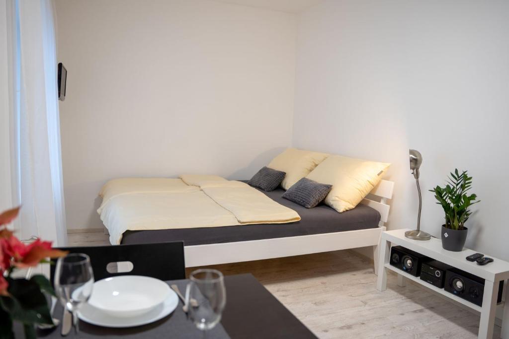 Habitación pequeña con 1 cama con mesa y comedor. en Byt Krenova 1+kk, en Brno