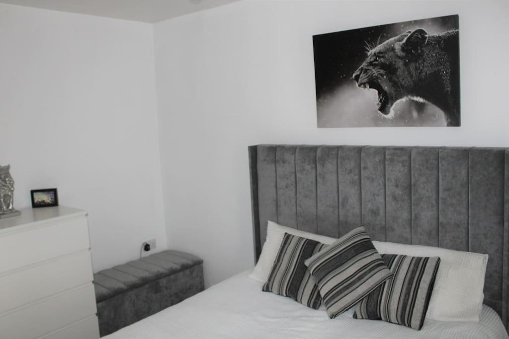 a bedroom with a bed with a wolf picture on the wall at Luxury Apartment Close to Town Centre in Lexden