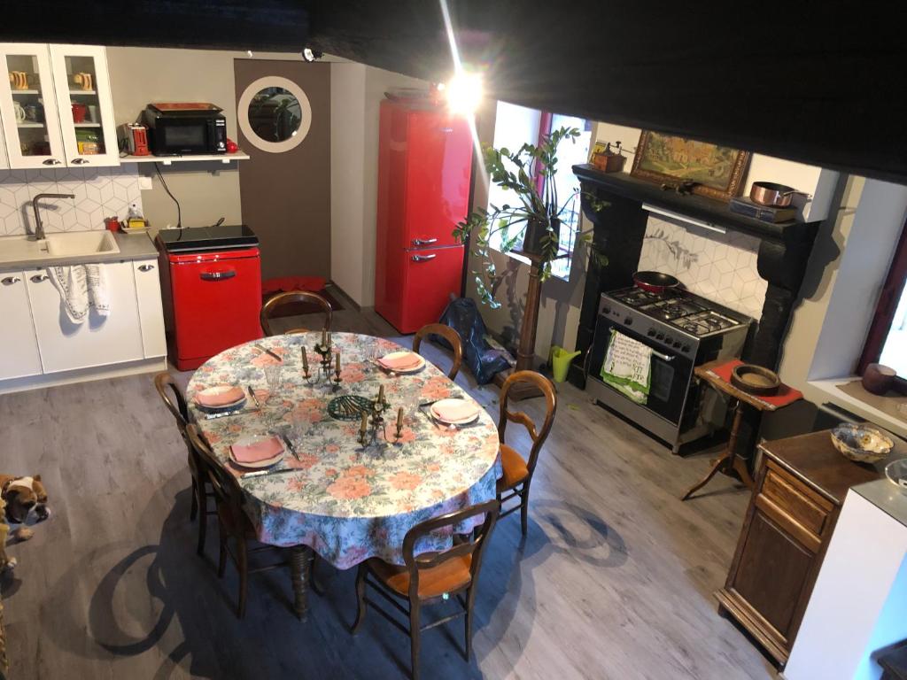 uma cozinha com uma mesa com cadeiras e um fogão em AUVERGNE Aux 3 boussets 
