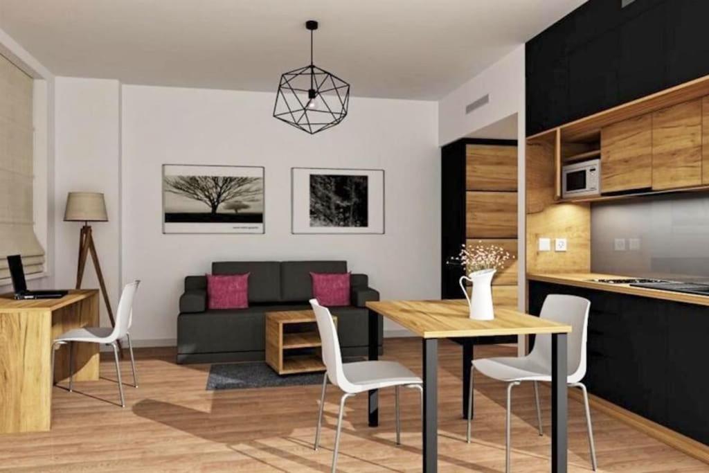 Il comprend une cuisine et un salon avec une table et des chaises. dans l'établissement Apartimento Hydral Viene, à Wrocław