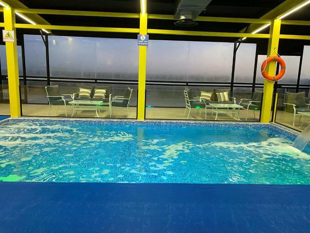 une piscine sur un bateau de croisière avec des tables et des chaises dans l'établissement צימר סוד החרמון, à Majdal Shams