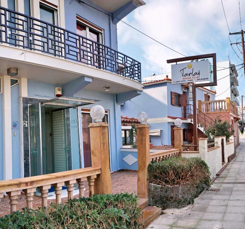 ein Gebäude mit einem Balkon und einem Schild darauf in der Unterkunft TARLAS ROOMS in Mytilini