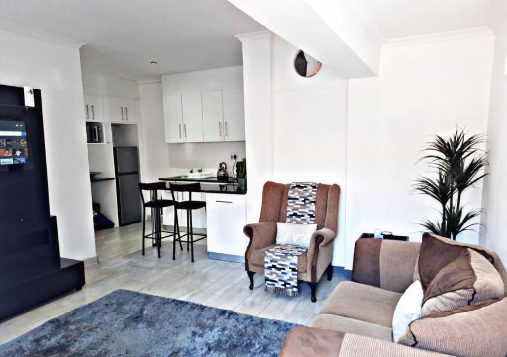 sala de estar con sofá y cocina en Feel@Home, en Ciudad del Cabo