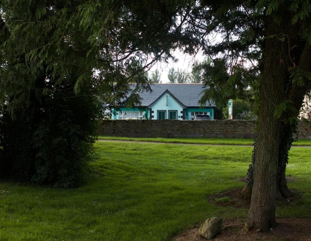 una casa en un campo con un árbol en Old School House Belcoo (43), en Belcoo