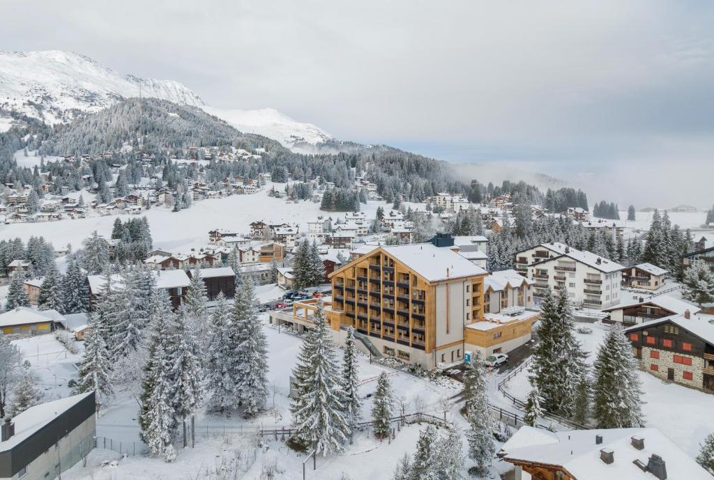 ein Ferienort im Schnee mit Bäumen und Gebäuden in der Unterkunft Valbella Resort in Lenzerheide