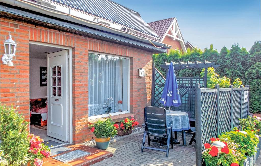 ein Backsteinhaus mit einer Terrasse mit einem Tisch und einem Sonnenschirm in der Unterkunft Amazing Apartment In Elmenhorst With Kitchen in Elmenhorst