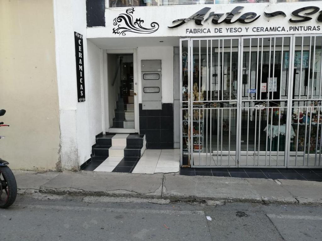 um edifício com um portão em frente a uma loja em hotel VALERY em San Gil