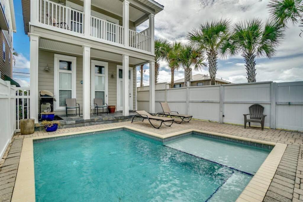 a swimming pool in front of a house with palm trees at Amzg Gulf view,4 Bd/3.5 Bath Home, Pvt heated Pool in Panama City Beach