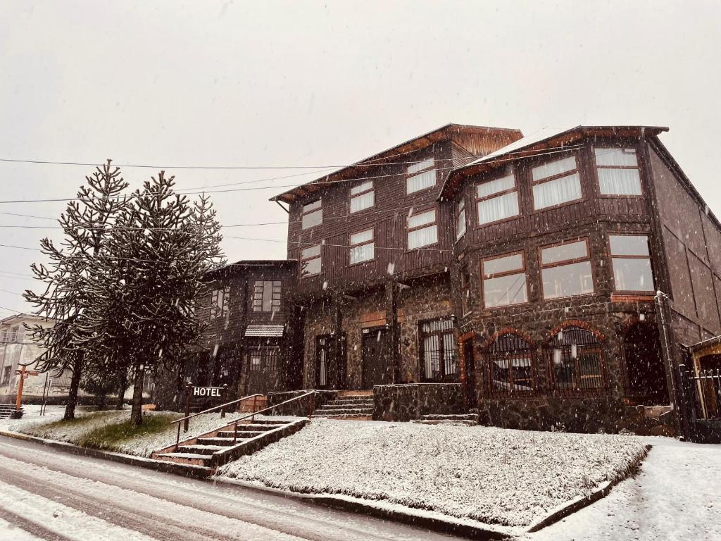 a large building on a street in the snow at HOTEL VOLKANICO in Curacautín