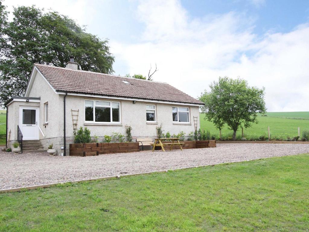 a white house with a picnic table in front of it at Braemorlich - UK10381 in Alford