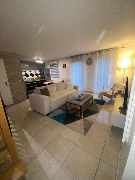 - un salon avec un canapé et une table dans l'établissement Appartement duplex T3 - Paris Jeux Olympiques - Roissy CDG - Parc des expositions - Disney - Astérix, à Villepinte