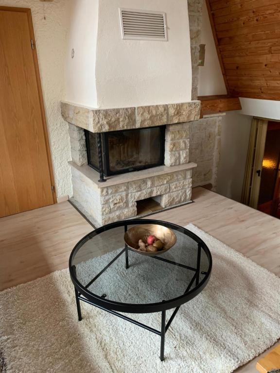 sala de estar con chimenea y mesa de centro de cristal. en Romantische Ferienwohnung Metzner, en Remptendorf