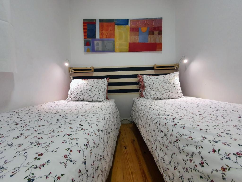 リスボンにあるCasa do Garcês by Lisbon Village Apartmentsのベッドルーム1室(隣り合わせのベッド2台付)