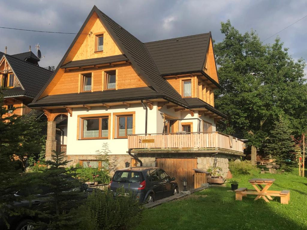 una casa con un coche aparcado delante de ella en Chata Kozica Kiry, en Kościelisko