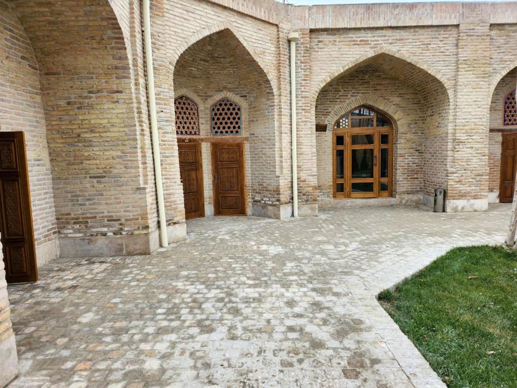 a large brick building with two wooden doors at Marhaba boutique Madrasah 15th-16th century in Bukhara