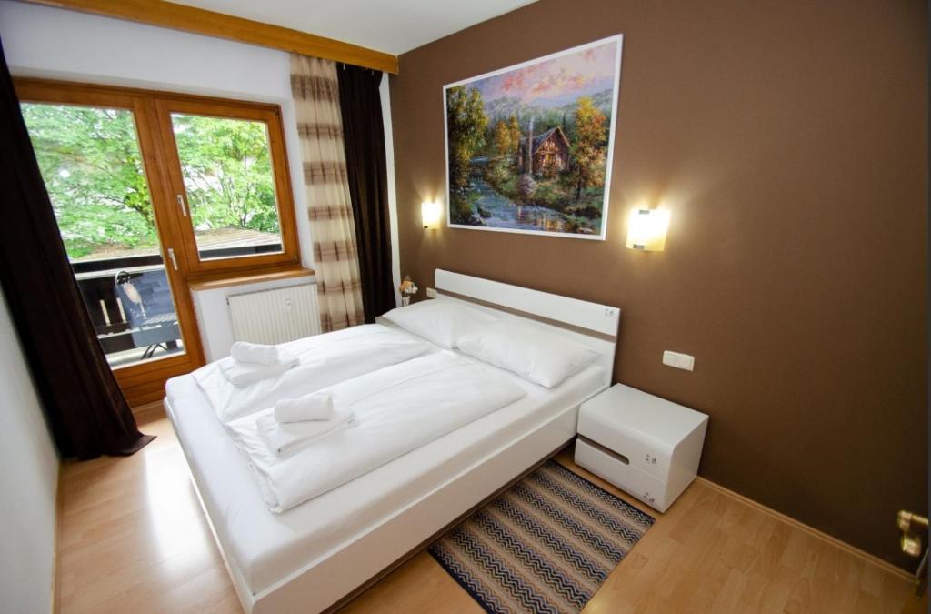 a white couch in a room with a painting on the wall at OTILIA apartment in Zell am See