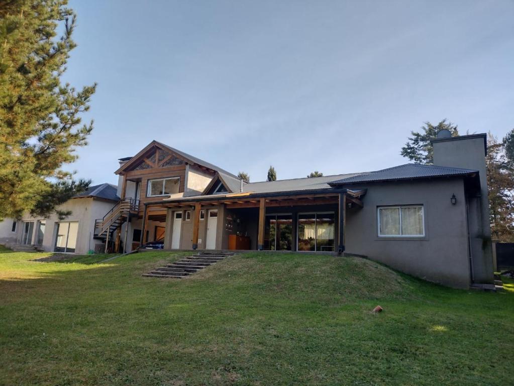 una casa con un gran césped delante de ella en Shalom Hospedaje en Tandil