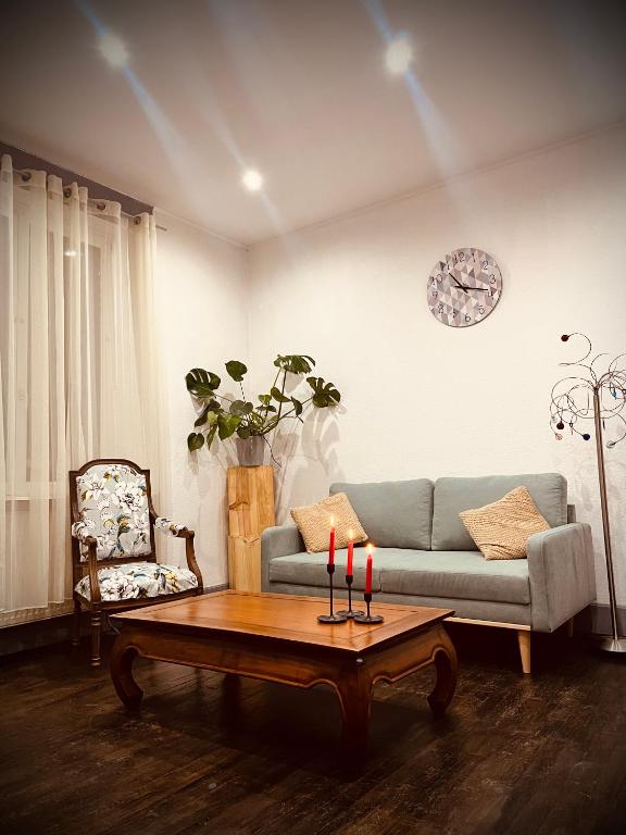 uma sala de estar com um sofá e uma mesa com velas em Petit prince chambre à louer em Saint-Dié-des-Vosges