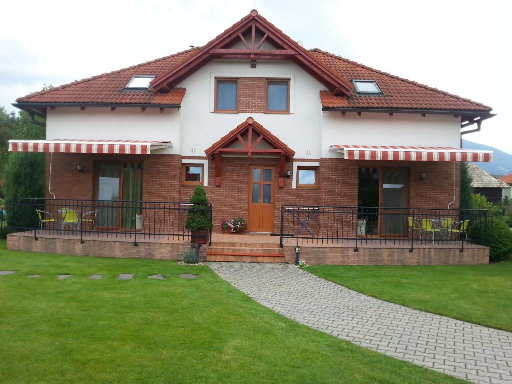 a house with a green lawn in front of it at Apartmany Svaty Kriz in Liptovský Mikuláš