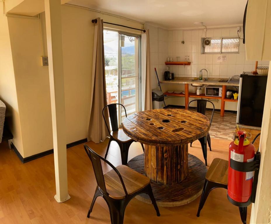 uma sala de estar com mesa e cadeiras e uma cozinha em Cabañas & Spa Qamawi em Pan de Azúcar