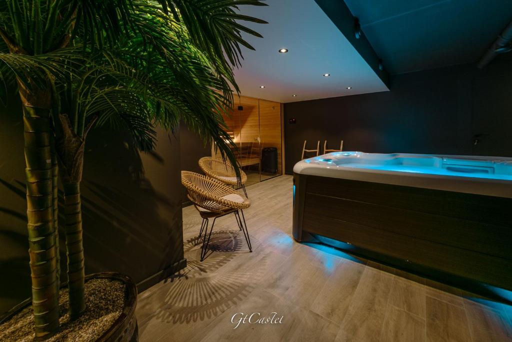 een badkamer met een bad en een palmboom bij Luxueus genieten aan zee: private jacuzzi en sauna in Knokke-Heist
