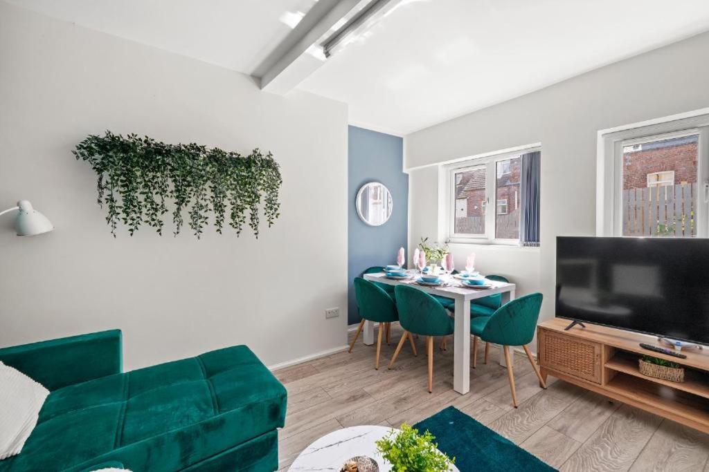 ein Wohnzimmer mit einer grünen Couch und einem Tisch in der Unterkunft Sleek 3 bedroom in Sheffield - Sleeps 8 in Wincobank