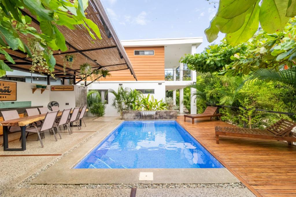 a swimming pool in a backyard with a table and chairs at Little Hawaii Avellanas in Playa Avellana