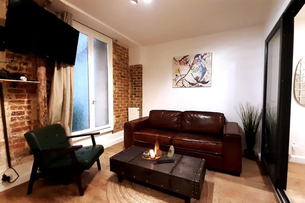 salon ze skórzaną kanapą i stołem w obiekcie Midnight in Paris Montmartre w Paryżu