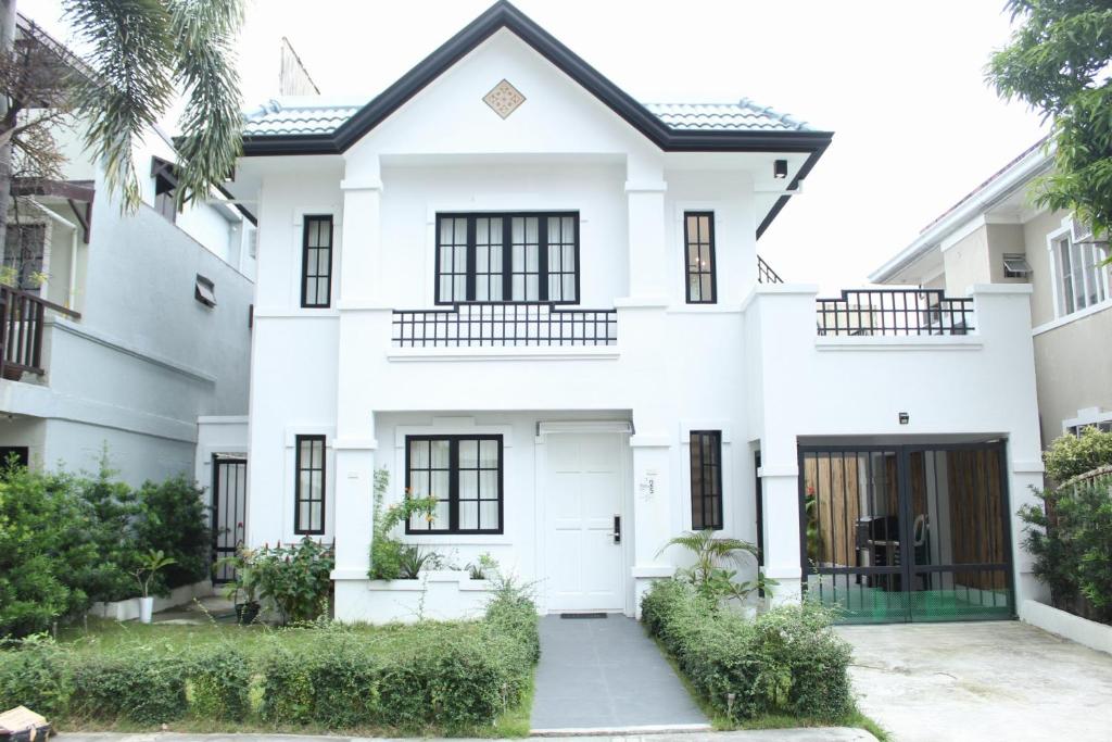 Casa blanca con ventanas negras en Exclusive Luxury Modern Home near Robinson's Place, en Manila