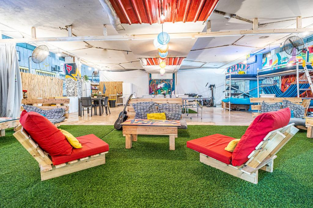 een woonkamer met 2 stoelen en een tafel bij Marina Ben Gurion Hostel in Tel Aviv