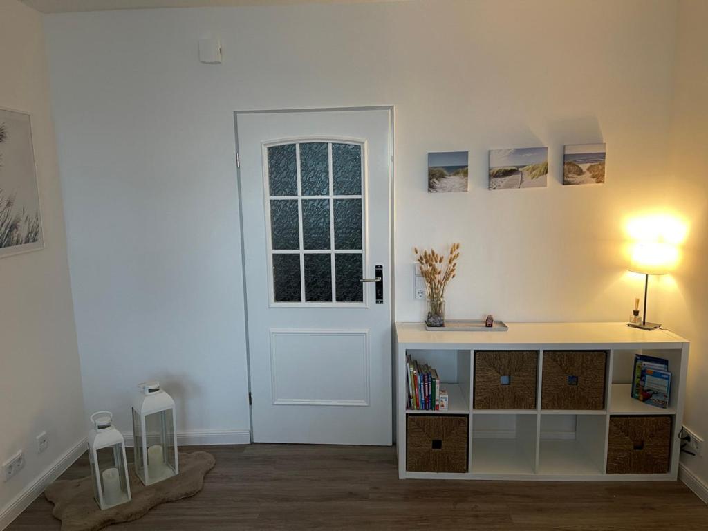 a room with a door and a table with a lamp at Strandstrasse34 in Laboe