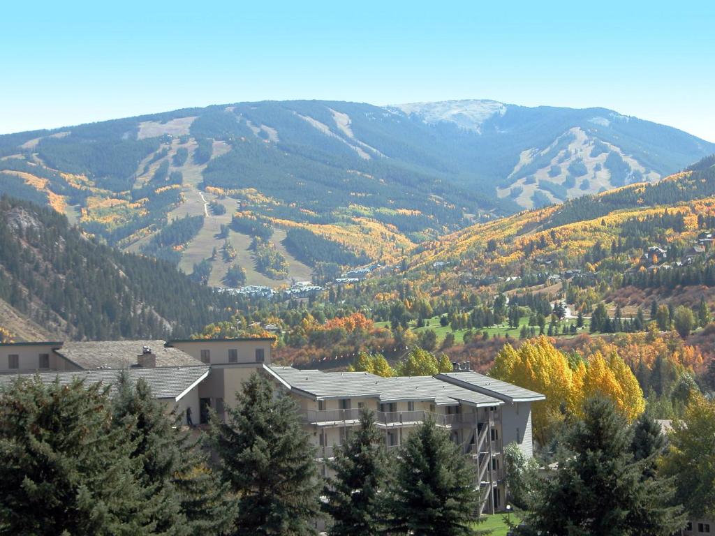 a building with trees and mountains in the background at Beaver Creek West Condos in Avon