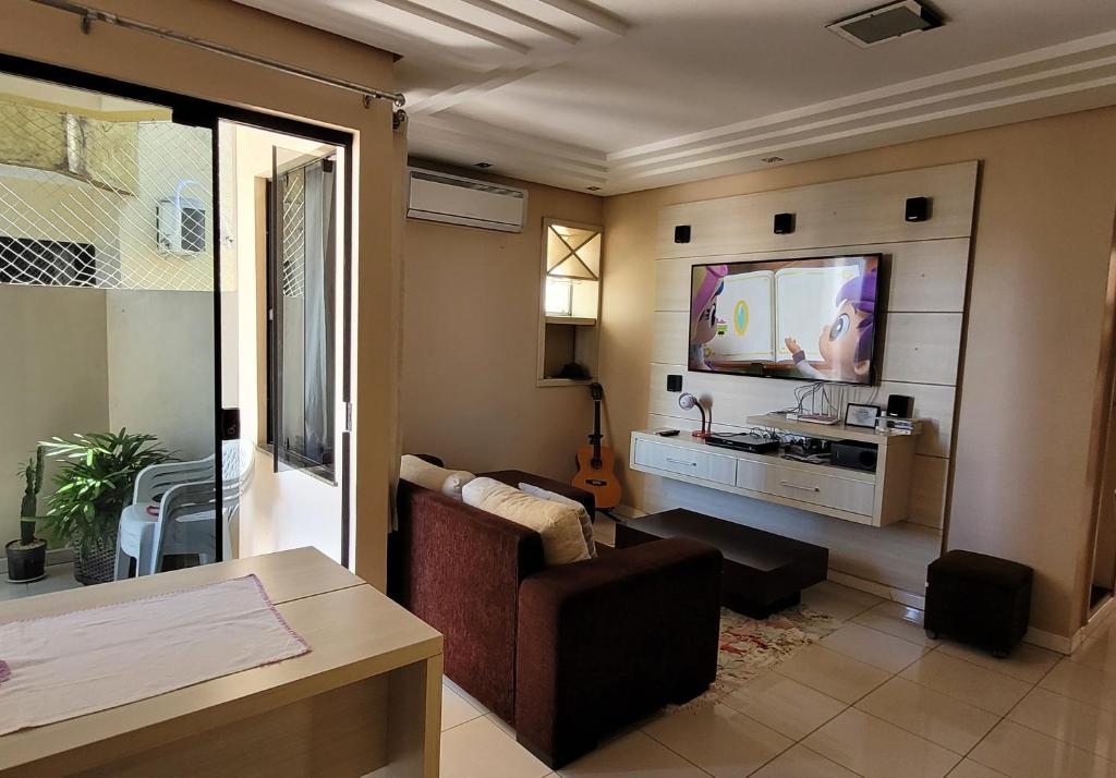 a living room with a couch and a flat screen tv at Apartamento no centro de Santarém-PA in Santarém