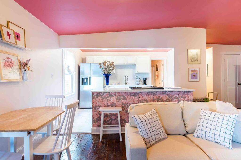 a living room with a couch and a kitchen at Blush And Bashful Germantown Two Bedroom Apartment in Louisville