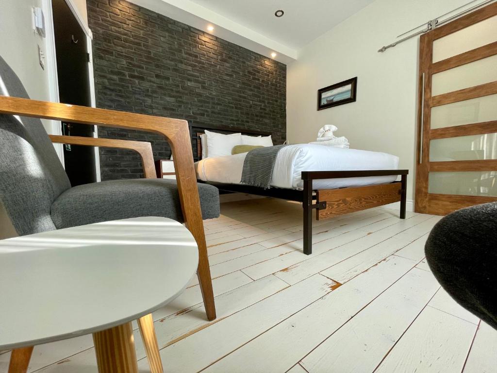 a bedroom with a bed and a chair at Domaine Belle Plage in Baie-Saint-Paul