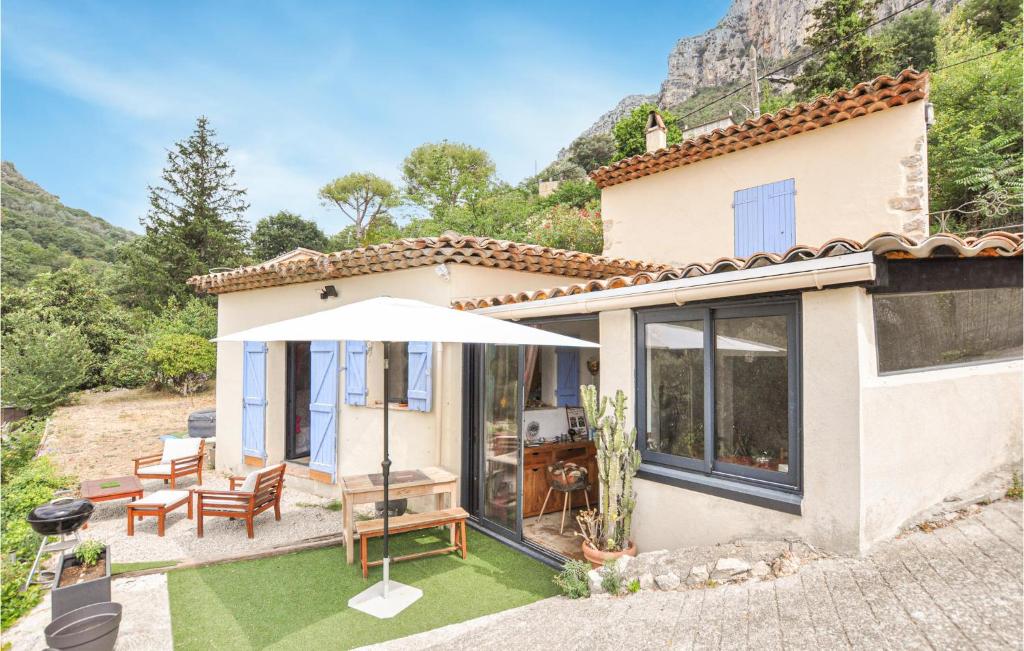 Cette petite maison dispose d'une terrasse avec un parasol. dans l'établissement Nice Home In Saint-Jeannet With Wifi, à Saint-Jeannet