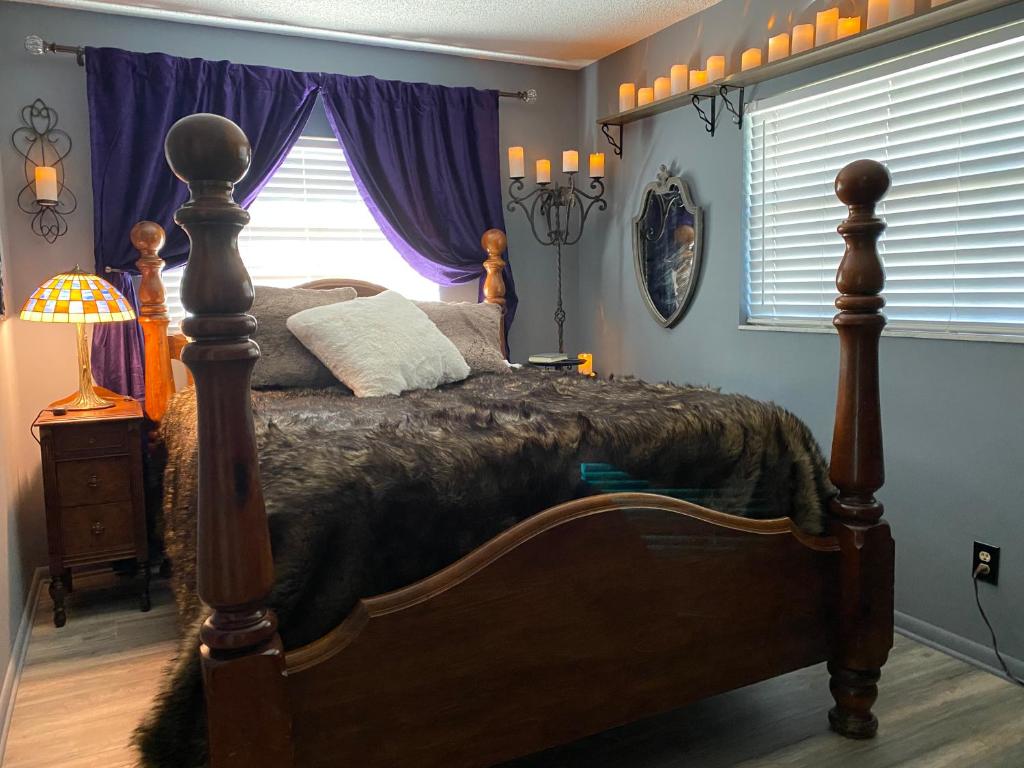 a bedroom with a bed and a window with purple curtains at Phantom History House Castle Room in Tampa