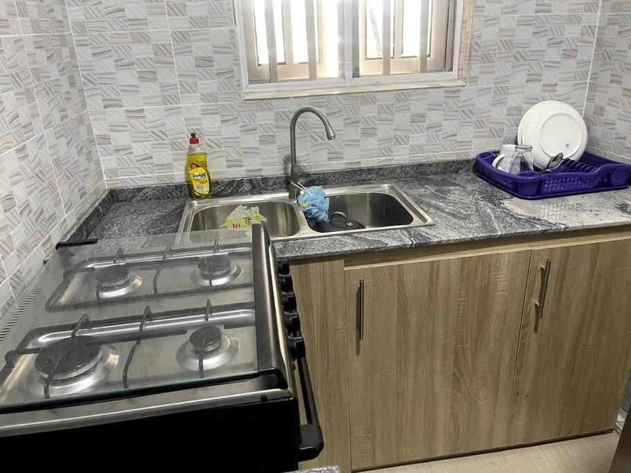 a kitchen with a sink and a stove at Beautiful 2Br Apt in Ogba, Ikeja, Lagos in Lagos